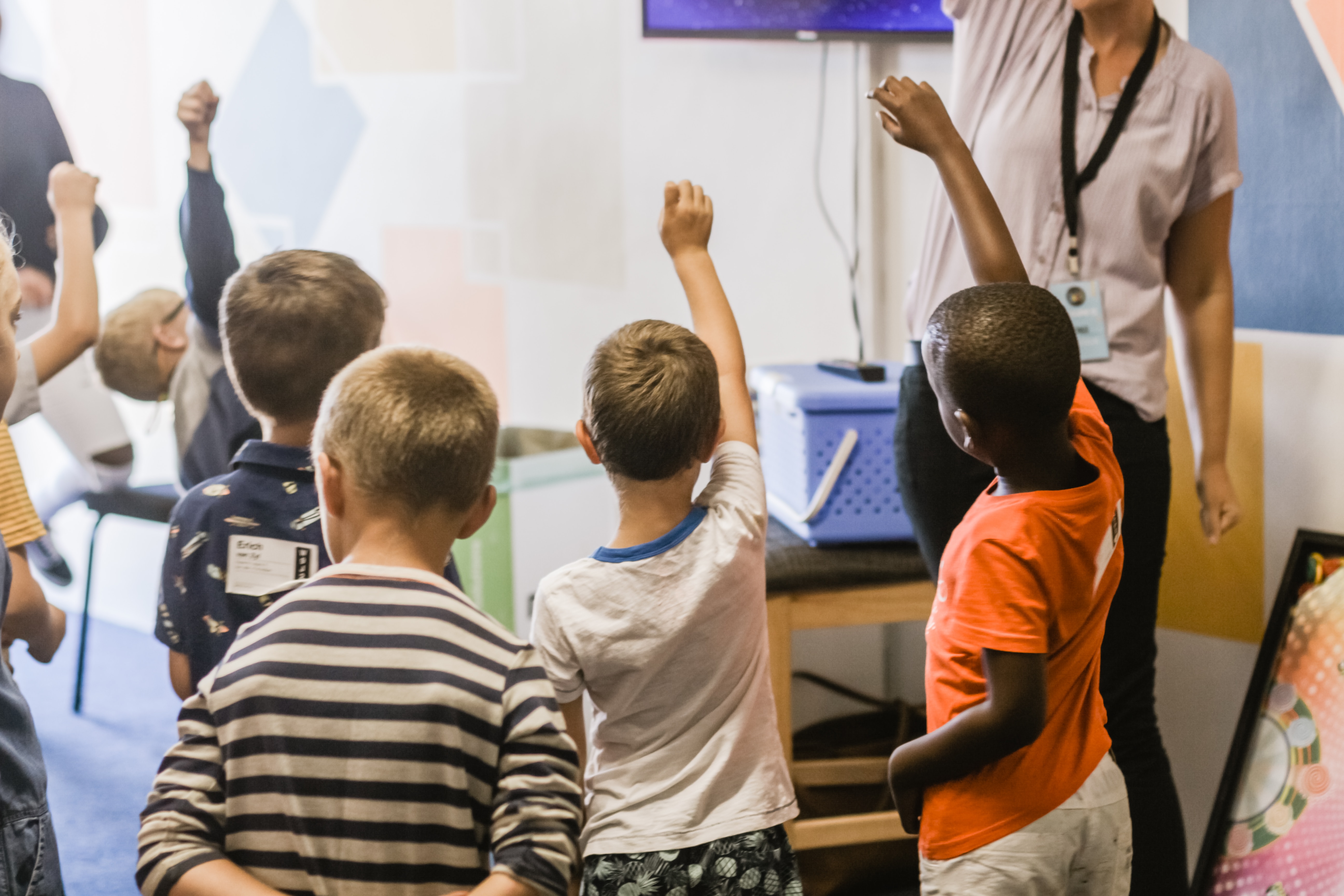 Students raising their hands in class.